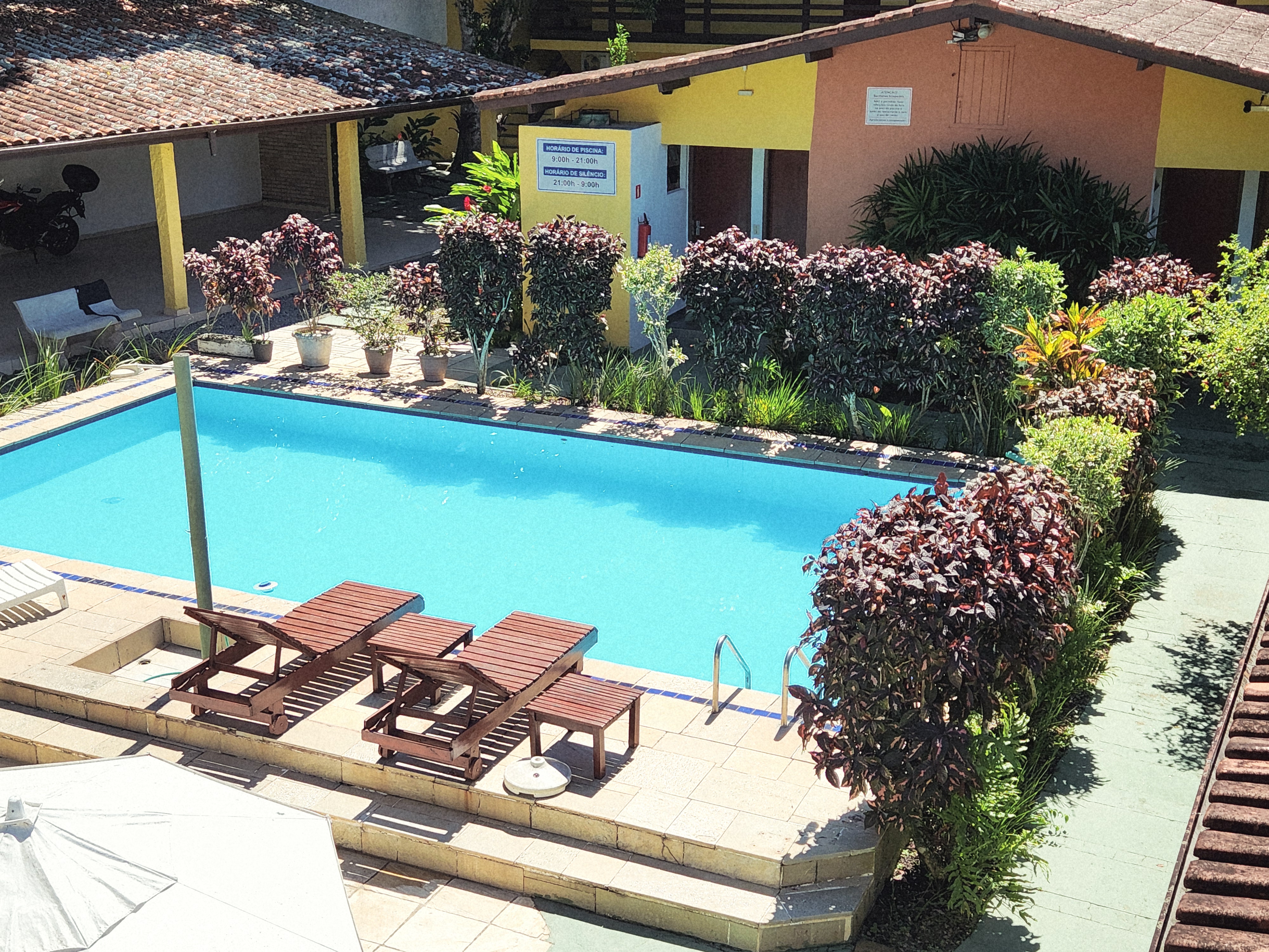 Vista ampla da piscina e das áreas comuns da pousada